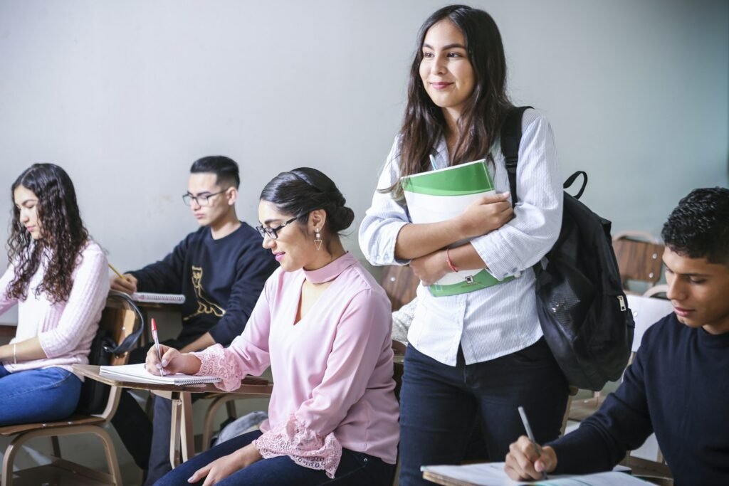 Students reviewing exam scorecard on laptop in a study setting