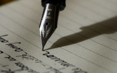 Student writing an essay in a notebook, representing IPMAT WAT preparation