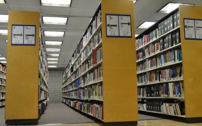 Rows of books on university library shelves